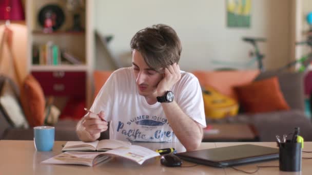 chlap sedící za stolem a píšící domácí úkoly - Záběry, video