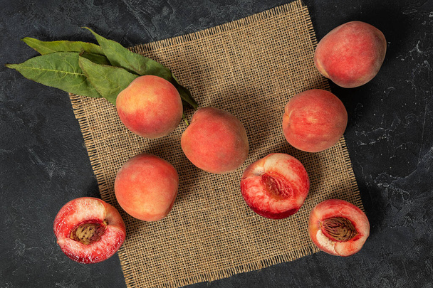 сочные спелые персиковые фрукты на темном фоне. сельскохозяйственная продукция, концепция сезона сбора урожая. - Фото, изображение