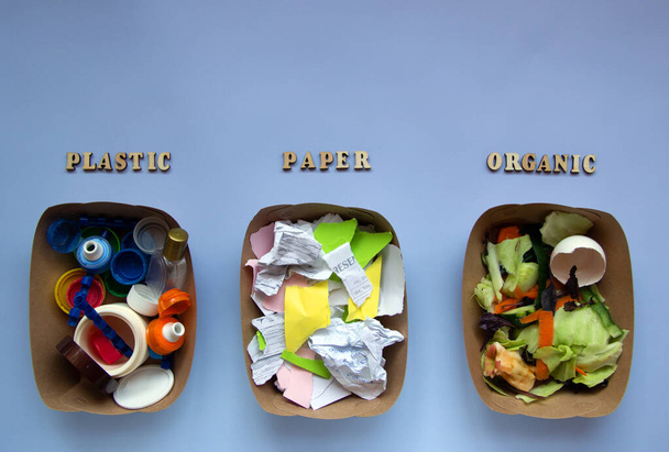Kolme konttia roskat sinisellä pohjalla: muovi, orgaaninen jäte, paperi. Kierrätä käsite. Ympäristökysymykset: jätteiden käsittely. Top view, tasainen lay. - Valokuva, kuva