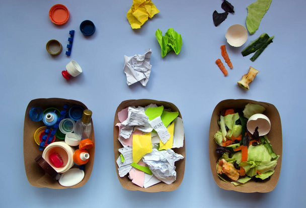 Kolme konttia roskat sinisellä pohjalla: muovi, orgaaninen jäte, paperi. Kierrätä käsite. Ympäristökysymykset: jätteiden käsittely. Top view, tasainen lay. - Valokuva, kuva