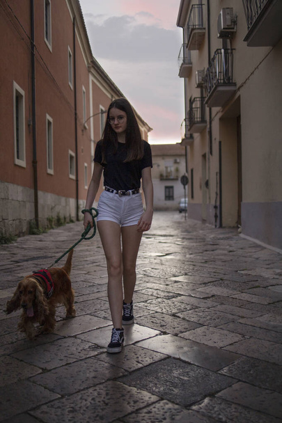 Teenage girl walking with dog in the city. Loving dogs is good for your health - Zdjęcie, obraz