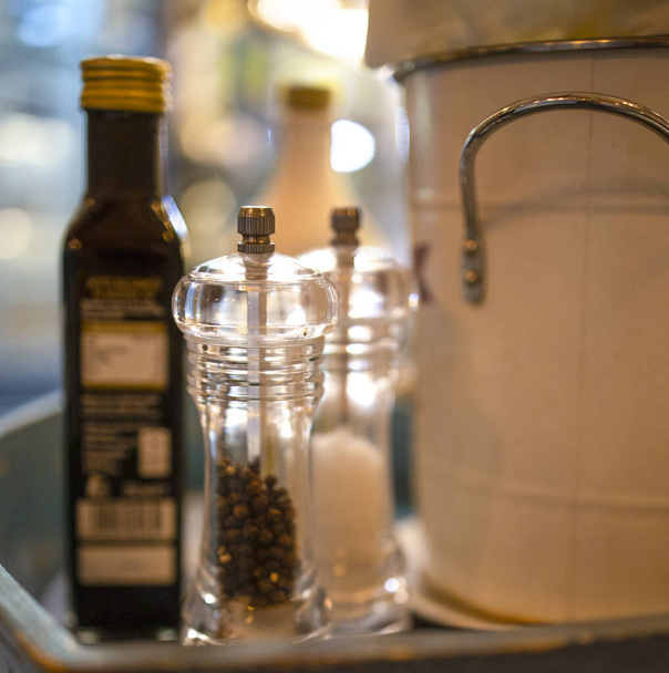 Селективный акцент на специи на столе в покое, соль, перец и оливковое масло - Фото, изображение