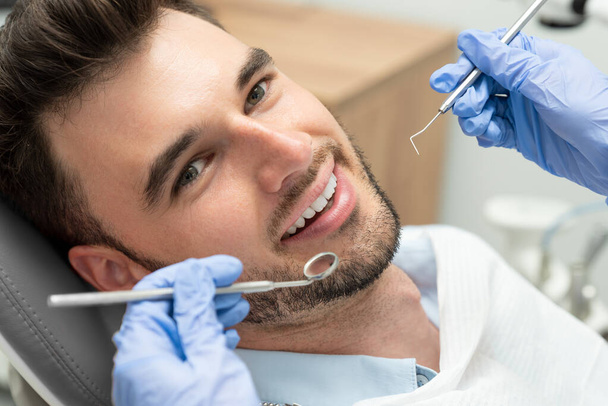 Man having teeth examined at dentists. Overview of dental caries prevention - Фото, изображение