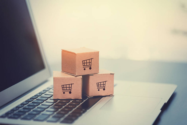 Boxes on laptop keyboard. E-commerce, online shopping concept. - 写真・画像