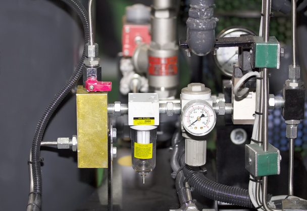 Cierre el manómetro y el filtro de aire para monitorear la cantidad y controlar el aceite a presión y el gas de la máquina para trabajos industriales en fábrica - Foto, imagen