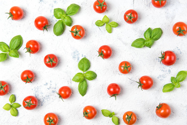 Fresh cherry tomatoes with basil leaves on a stone table, vegetable pattern, top view - Foto, Imagem