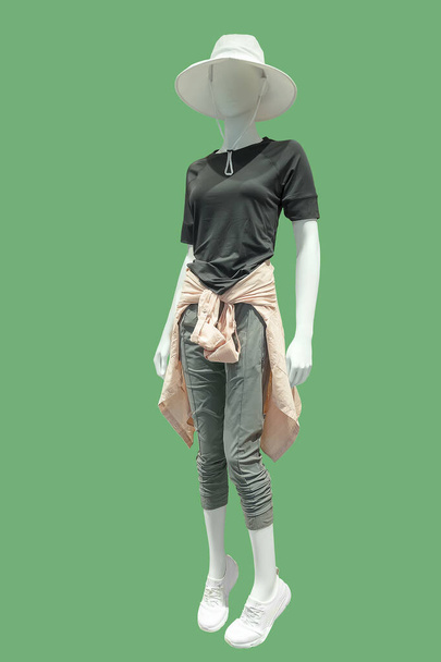 完全な長さの女性のマネキンは緑の背景で隔離された夏のカジュアルな服で身に着けていた。ブランド名や著作権の対象外. - 写真・画像
