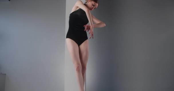 Kaunis nuori ballerina mustassa lavapuvussa, jossa on avoimet selkäharjoitukset tanssiliikkeet, balettiharjoitukset, tanssiminen teräväkärkisissä kengissä varpaissa, tanssistudion oppitunti, 4k 60p Prores HQ 10 bit - Materiaali, video