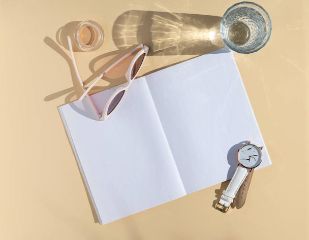 Feminine blogger notes mockup. Top view womens accessories, glass with water and opened blank notepad. Blank paper sheet with space for text - Foto, immagini