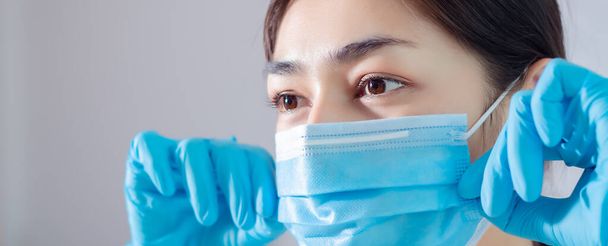 Aziatisch meisje dragen een blauw masker.neus masker beschermt tegen stof op het gezicht van vrouwen. - Foto, afbeelding