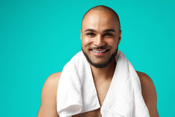 Mixed-race man with towel against turquoise background - Fotografie, Obrázek