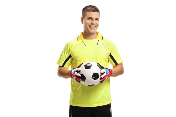 Fußball-Torwart hält einen Ball und lächelt isoliert auf weißem Hintergrund - Foto, Bild
