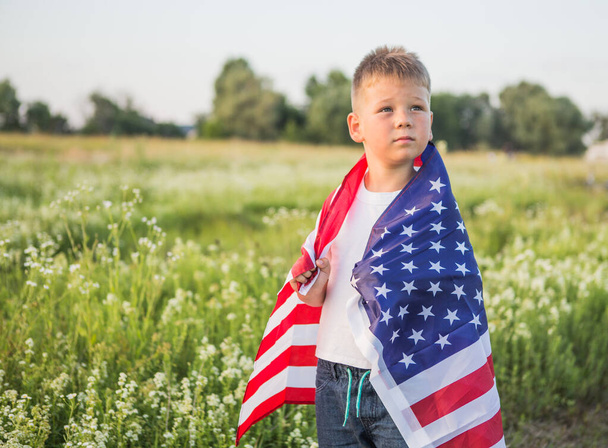 Nuori poika 4-vuotias pitäen Amerikan lippua auringonlaskun aikaan pellolla - Valokuva, kuva