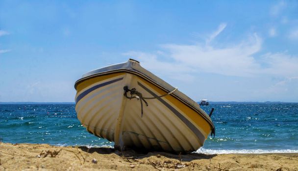 Mała łódź zacumowana na plaży na Morzu Egejskim. - Zdjęcie, obraz