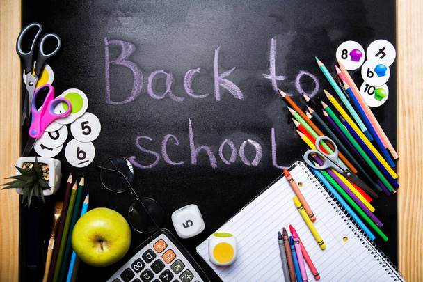 style school elements - book, pen, pencils,  apple on blackboard. Back to school design template. - Photo, Image