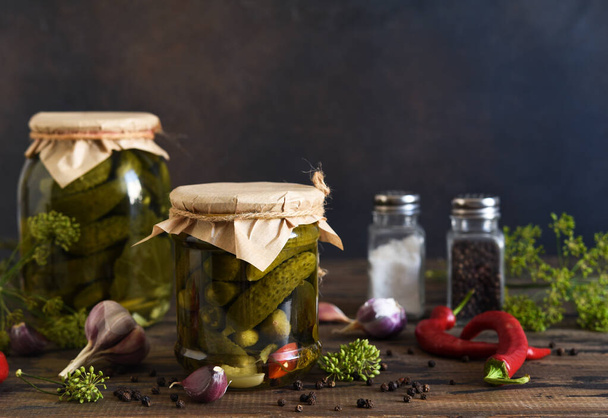 Pickled cucumbers with dill and garlic in a glass jar. - Фото, изображение