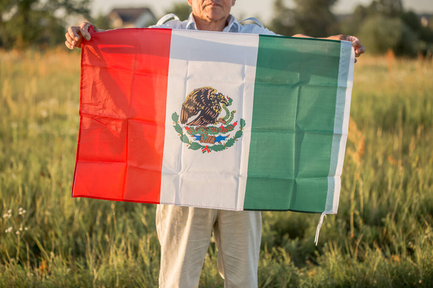 Älterer Mann mit mexikanischer Flagge. "16. September. Unabhängigkeitstag Mexikos. Mexikanischer Unabhängigkeitskrieg, 1810." - Foto, Bild