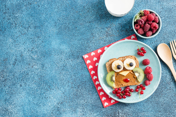 かわいいフクロウの形をした子供たちのための面白い朝食トースト。子供のためのフードアートサンドイッチ。隔離されてる。動物の顔は広がり、果物で乾杯 - 写真・画像