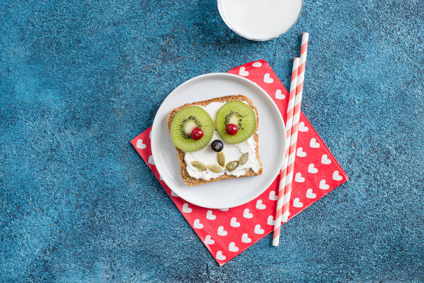 Funny breakfast toast for kids shaped as cute dog. Food art sandwich for child. Isolated. Animal faces toasts with spreads, fruits - Photo, Image