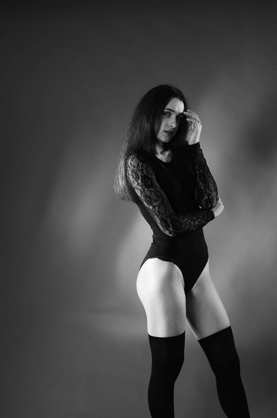 beautiful brunette young woman in black bodysuit posing on dark studio background  - Fotoğraf, Görsel