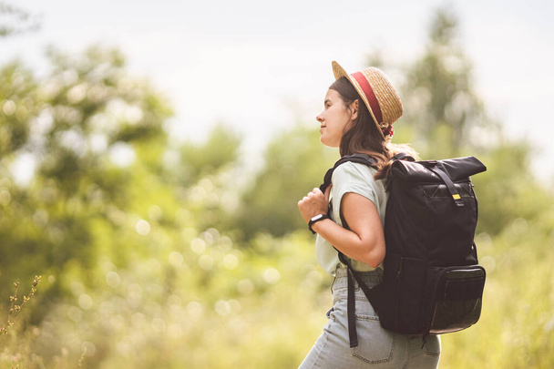 Young travel girl at viewpoint. Hipster girl with backpack. Travel concept. Beautiful woman hiker enjoying amazing landscapes. Holiday vacation and freedom. Back view. Traveller Walking In Nature. - Photo, Image
