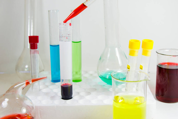 Elementi chimici liquidi di laboratorio e diagnosi di ricerca, strumenti e oggetti nella tavola sterile, vetreria e pipetta. Studio sparare. - Foto, immagini