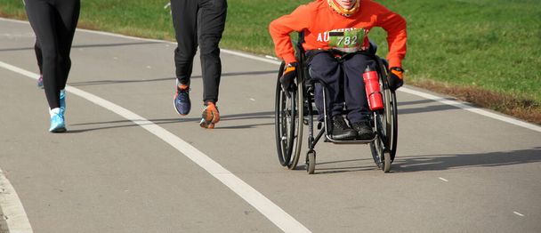 Vammaiset urheilijat pyörätuolissa osallistuvat juoksukilpailuun - Valokuva, kuva
