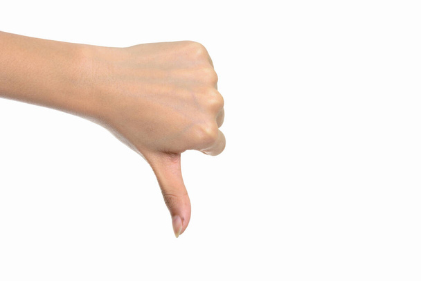 Studio shot of hand giving thumbs down against white background - Photo, image