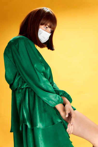 女性でファッションドレスポーズで医療マスクウイルスcovid-19 - 写真・画像