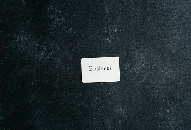 obchodní consept, vizitka s obchodním spisem v držení rukou žen, na černém betonovém pozadí - Fotografie, Obrázek