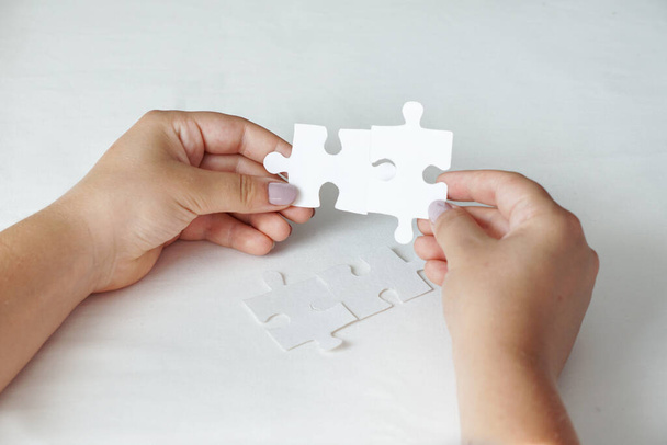 Concept of business, women hands holding white puzzle pieces - Photo, Image