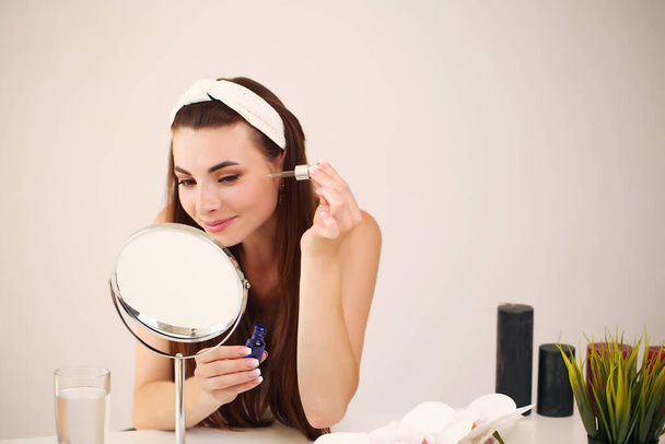 sitting at home, looking in the mirror, laughing and having fun. Morning skin care regimen. - Photo, Image