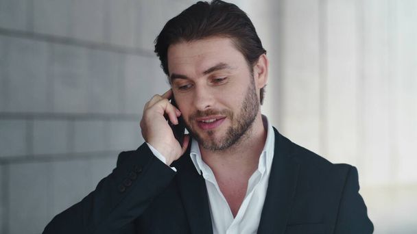 Businessman talking on cellphone with colleague outside. Man celebrating success - Foto, Imagen