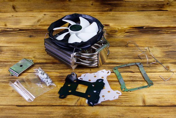 Modern CPU cooler with installation kit on a wooden desk - Photo, Image
