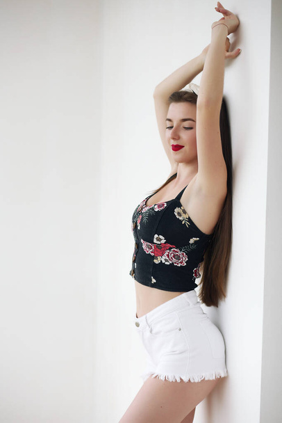 beautiful girl in shorts and top posing in studio - Fotó, kép