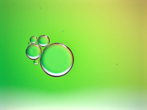 Primer plano verde claro hermoso aceite burbujas con color dulce, imagen macro, fondo abstracto, fondo de pantalla brillante, gotas de agua borrosa, color pastel para el diseño de tarjetas - Foto, imagen