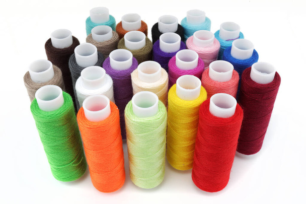 Carretes de algodón multicolor sobre una superficie blanca
 - Foto, imagen