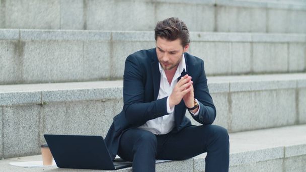 ビジネスマンは通りでノートパソコンを入力します。スーツを着た男がオフィスの外で働いて - 写真・画像