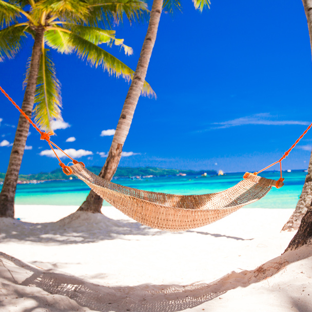 Stroh-Hängematte im Schatten der Palmen am tropischen Strand am Meer - Foto, Bild