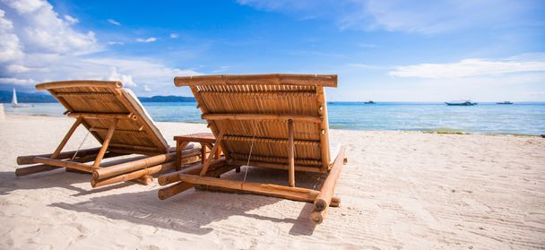 Пляжные деревянные стулья для отдыха на тропическом пляже
 - Фото, изображение