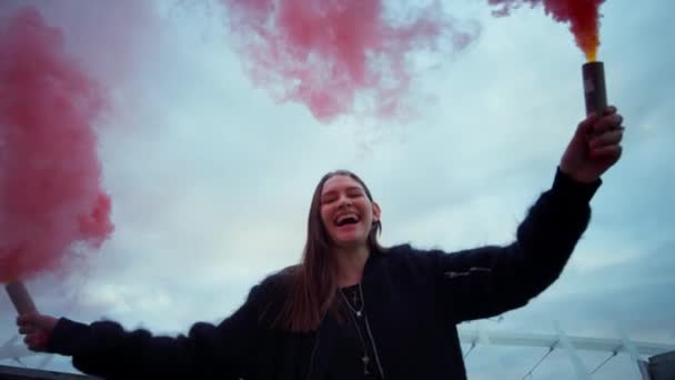 Girl moving smoke bombs in hands. Woman posing on street in colorful smoke - Footage, Video