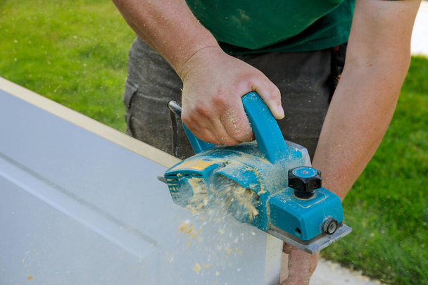 Elektrický hoblík pro zpracování dřevěných dveří profesionální pomocí řemeslného zařízení s ručním hoblíkem - Fotografie, Obrázek