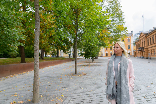 Şehir merkezindeki huzurlu meydanda güzel sarışın bir İskandinav kadının portresi. - Fotoğraf, Görsel