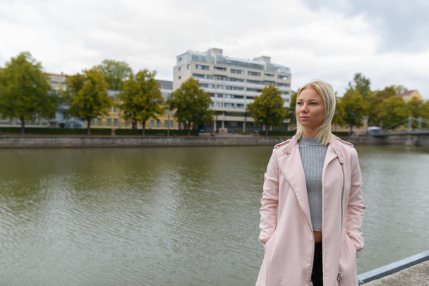 Porträt einer jungen schönen blonden Skandinavierin, die sich am Fluss entspannt - Foto, Bild