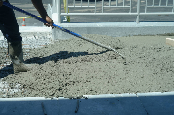 Työntekijöiden sementin käyttö pihatien rakennustyömaalla                                - Valokuva, kuva