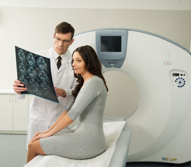 Médico com paciente jovem olhando para os resultados da tomografia computadorizada
 - Foto, Imagem