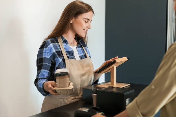 Női barista klienssel a modern kávézóban - Fotó, kép