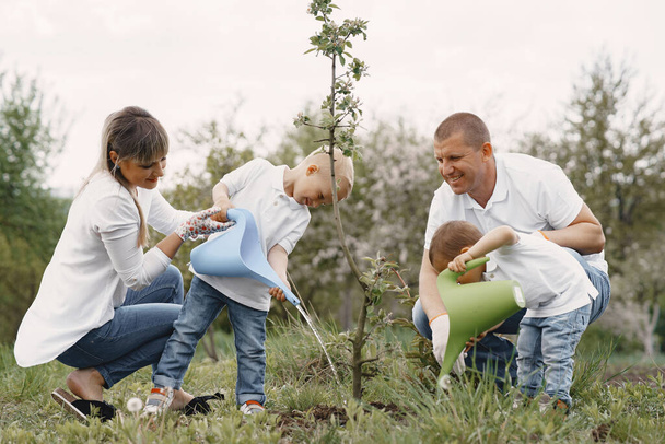 Family with with little sons are planting a tree on a yard - Fotoğraf, Görsel
