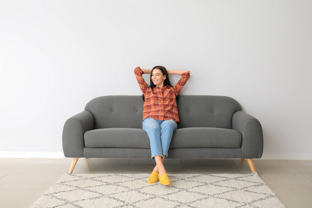 Mujer joven relajándose en el sofá en casa - Foto, imagen