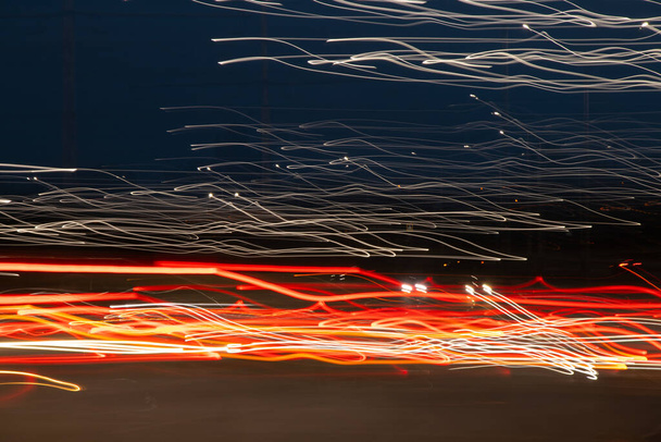Οδήγησε τα αυτοκίνητα τη νύχτα σε μια μακρά έκθεση τη νύχτα στο δρόμο στις πόλεις της Δνείπερου στην Ουκρανία - Φωτογραφία, εικόνα